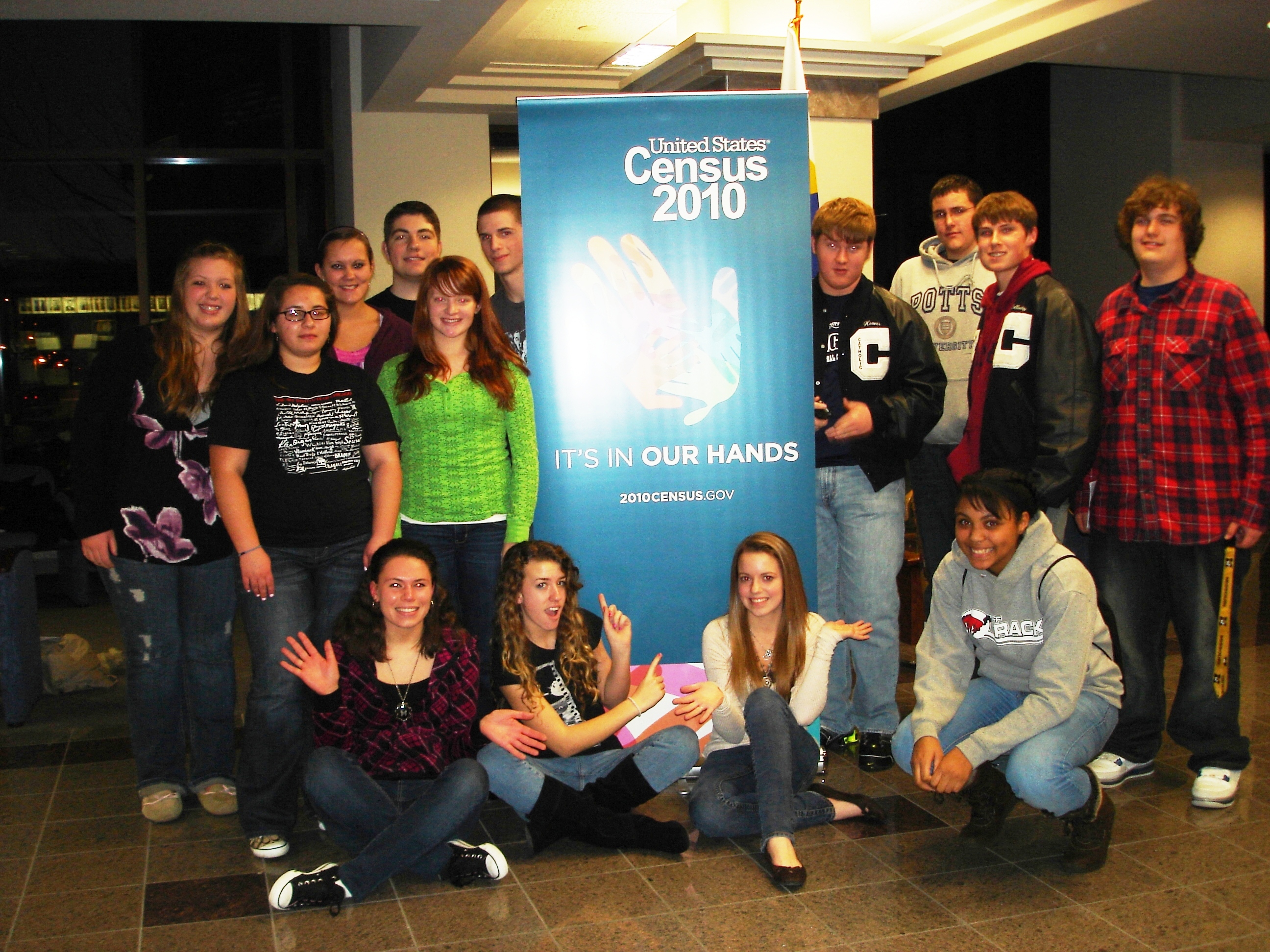 A group of teens in front of a 2010 Census banner